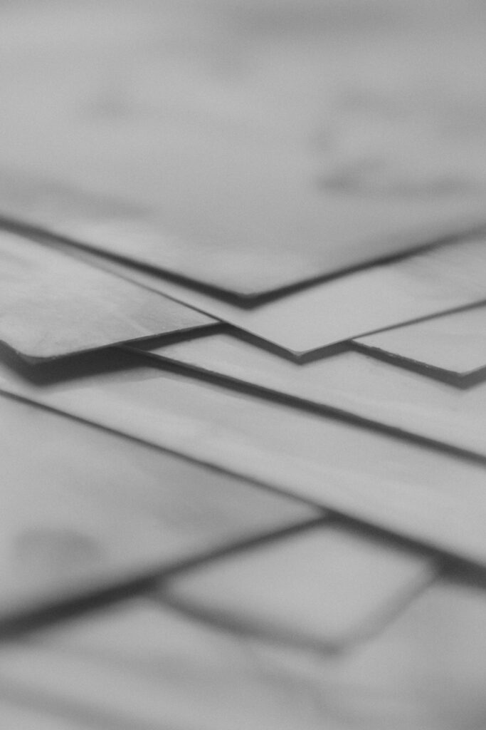 Close-up of overlapping paper layers in grayscale, creating an abstract artistic effect.