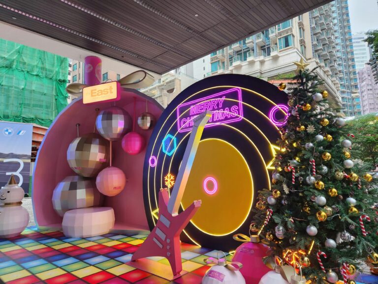 Vibrant Christmas setup in Hong Kong featuring neon signs and a decorated tree for a festive celebration.