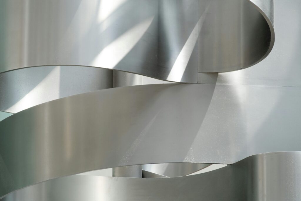 Close-up of a smooth, modern metallic facade with abstract curves and lines.