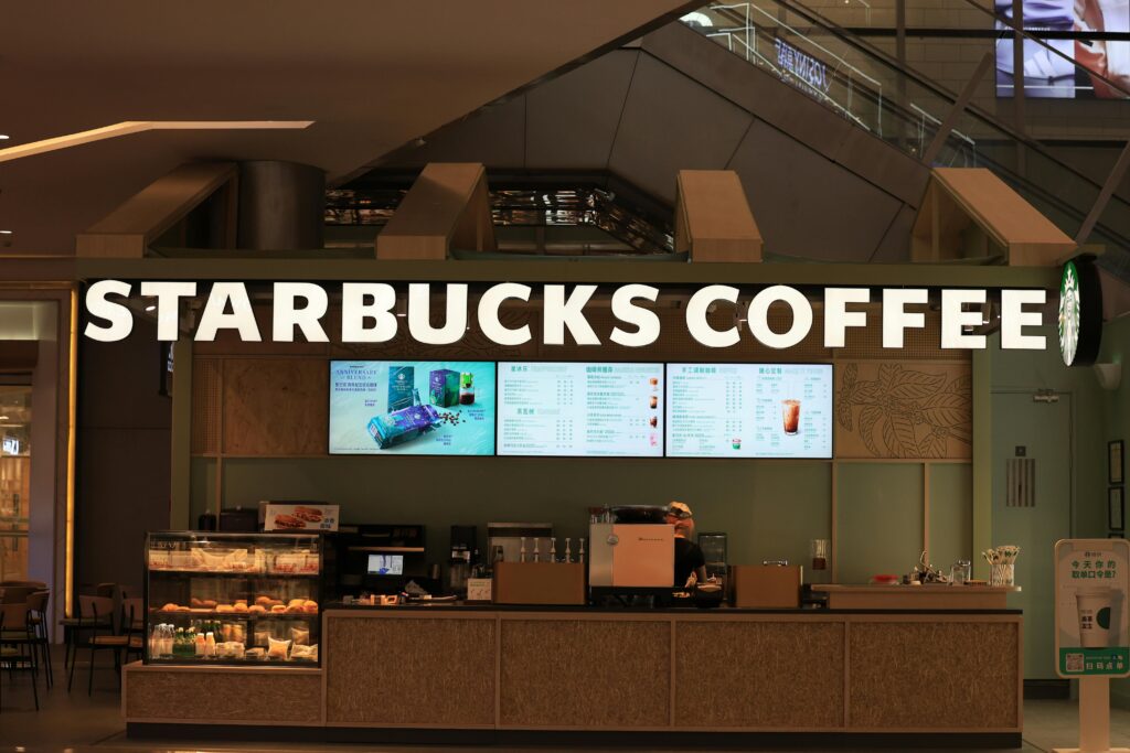 Interior view of a Starbucks Coffee shop with menu displays and counter setup.