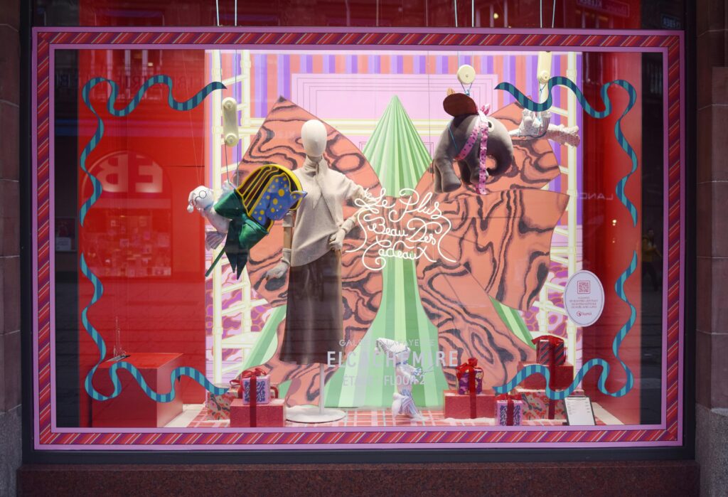 Colorful Strasbourg window display featuring mannequins and holiday decor. Perfect for festive and retail themes.