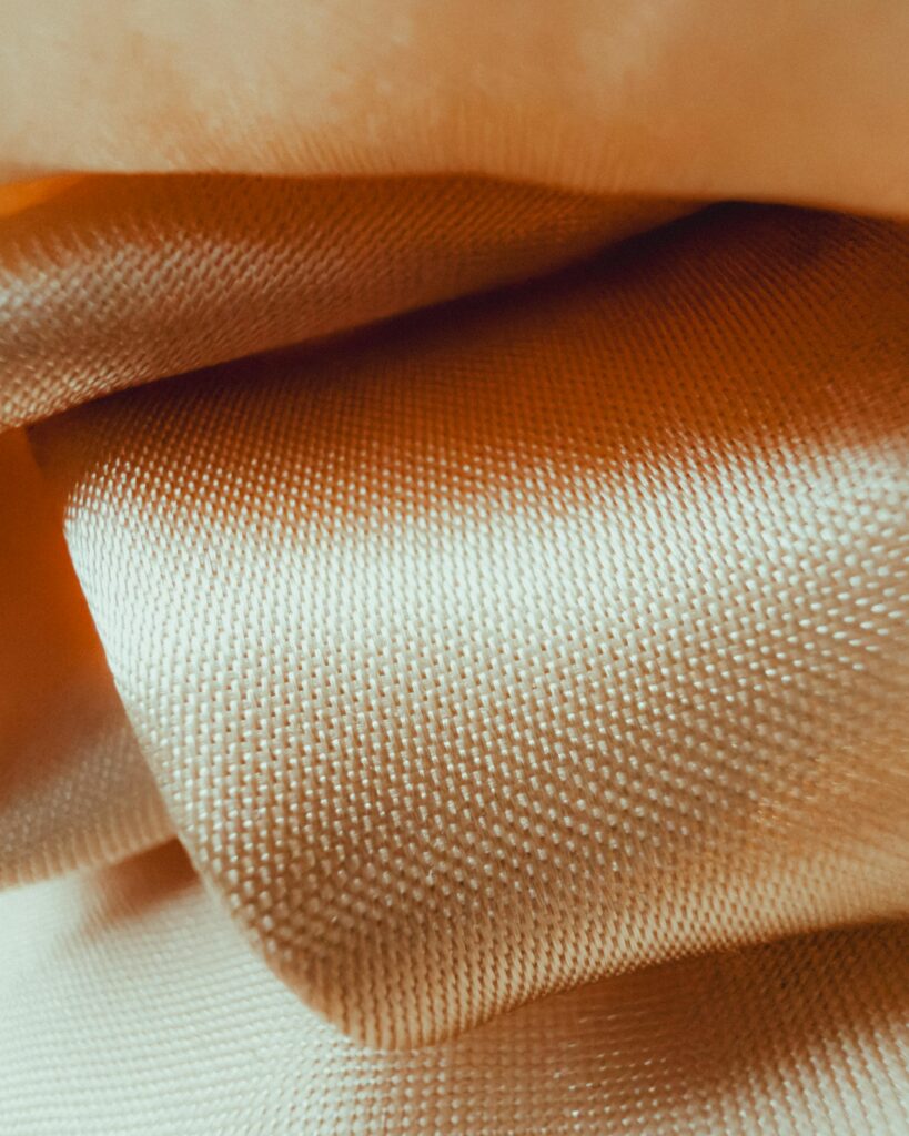 Detailed close-up of soft orange fabric folds with textured surface.