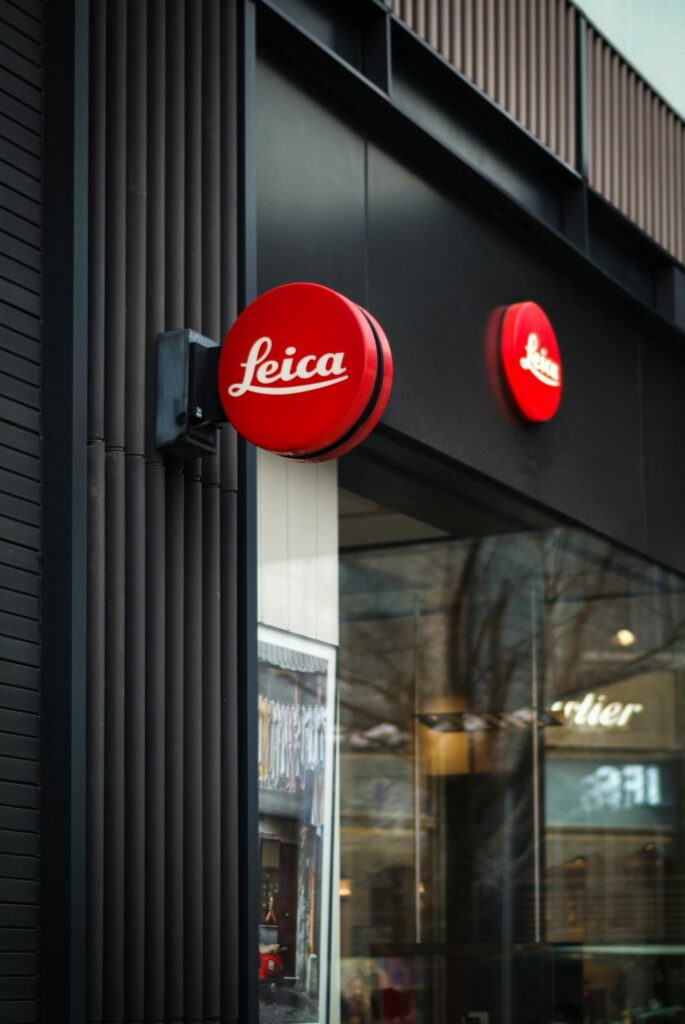 Vertical shot of a modern Leica store facade, highlighting urban architectural design.